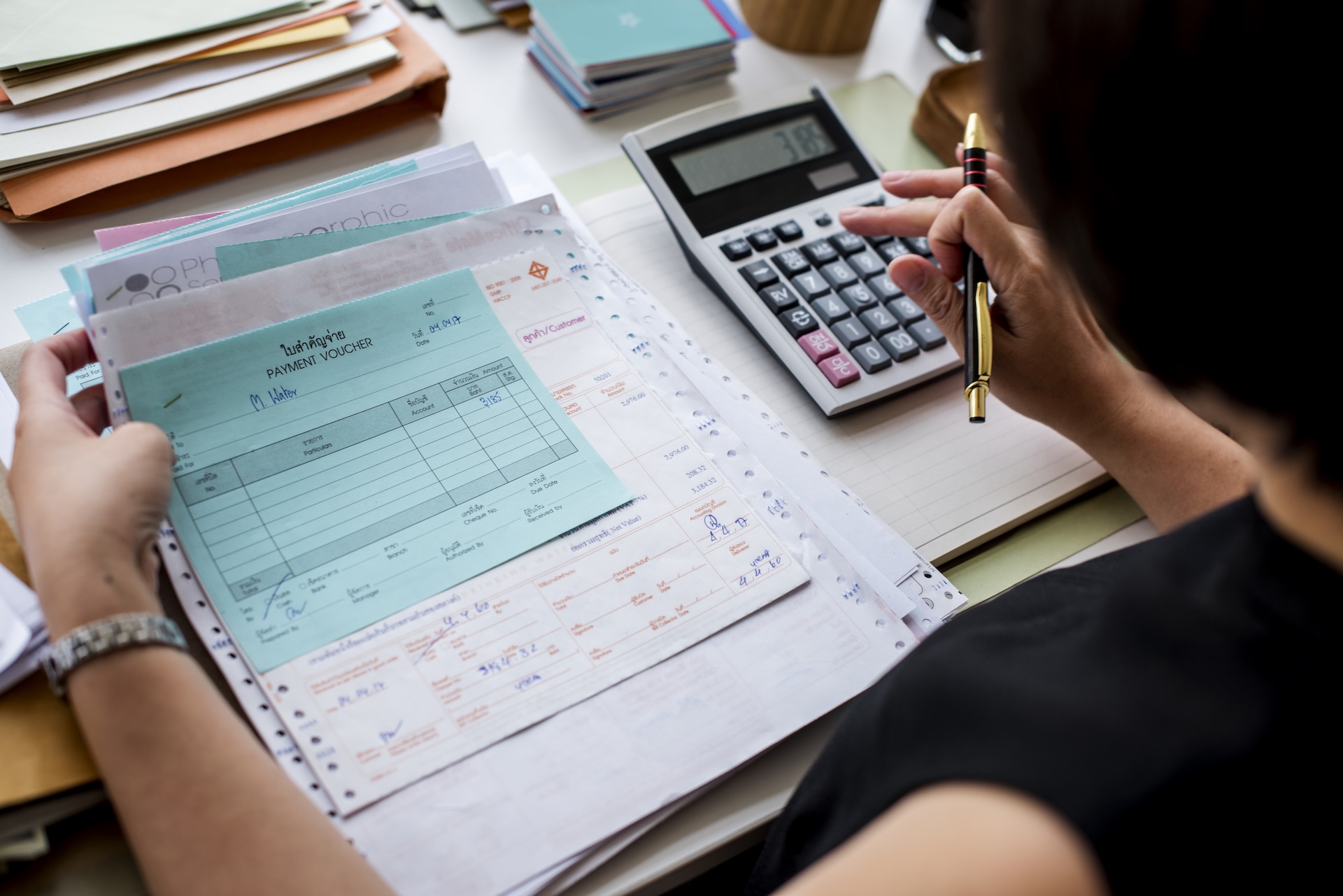 Fórmula del punto de equilibrio. Directivo usando una calculadora para mostrar como se hace el punto de equilibrio de una empresa paso a paso.