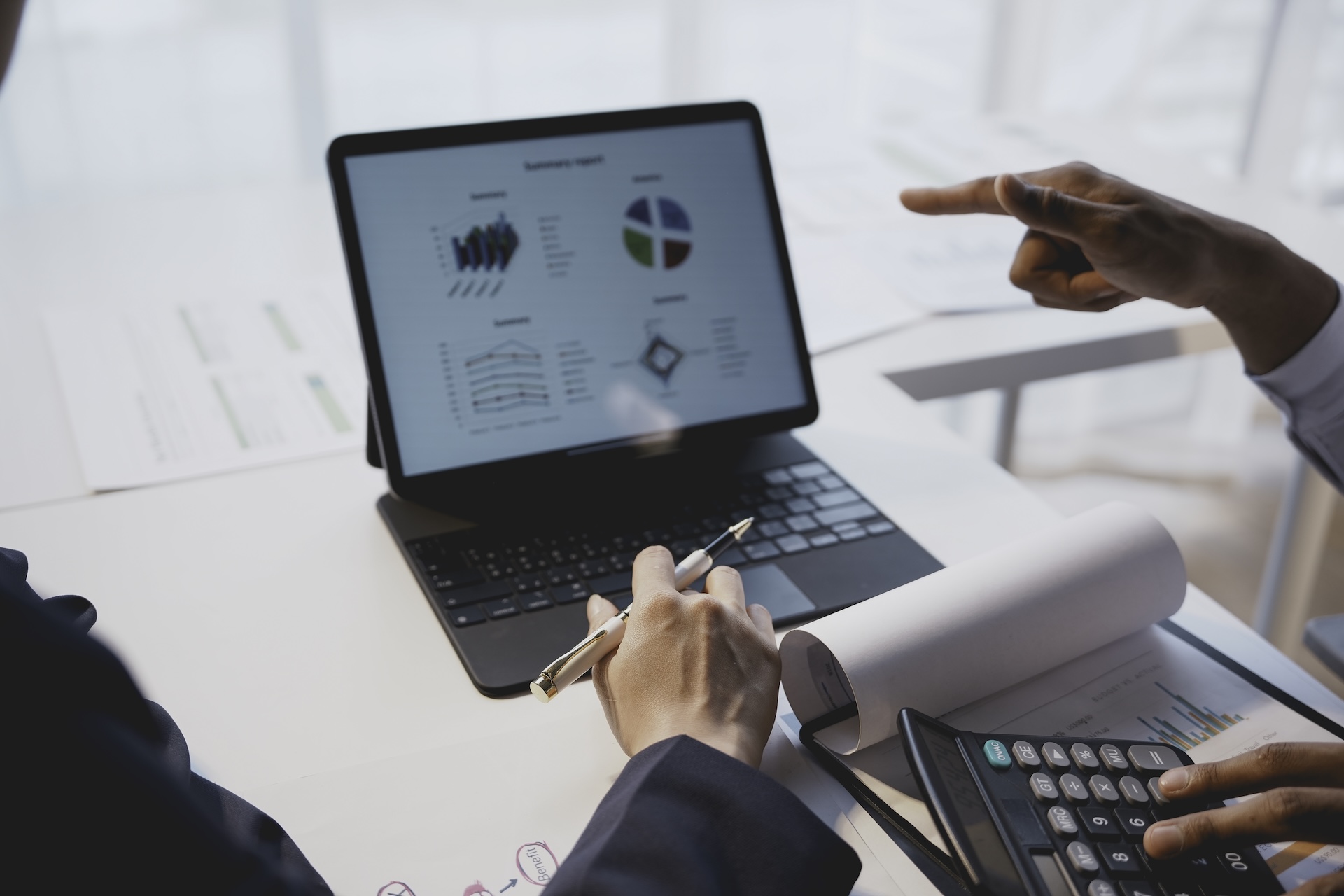 Dos profesionales revisando cuadros de mando en una tablet y analizando métricas financieras durante una sesión de mentorización empresarial.