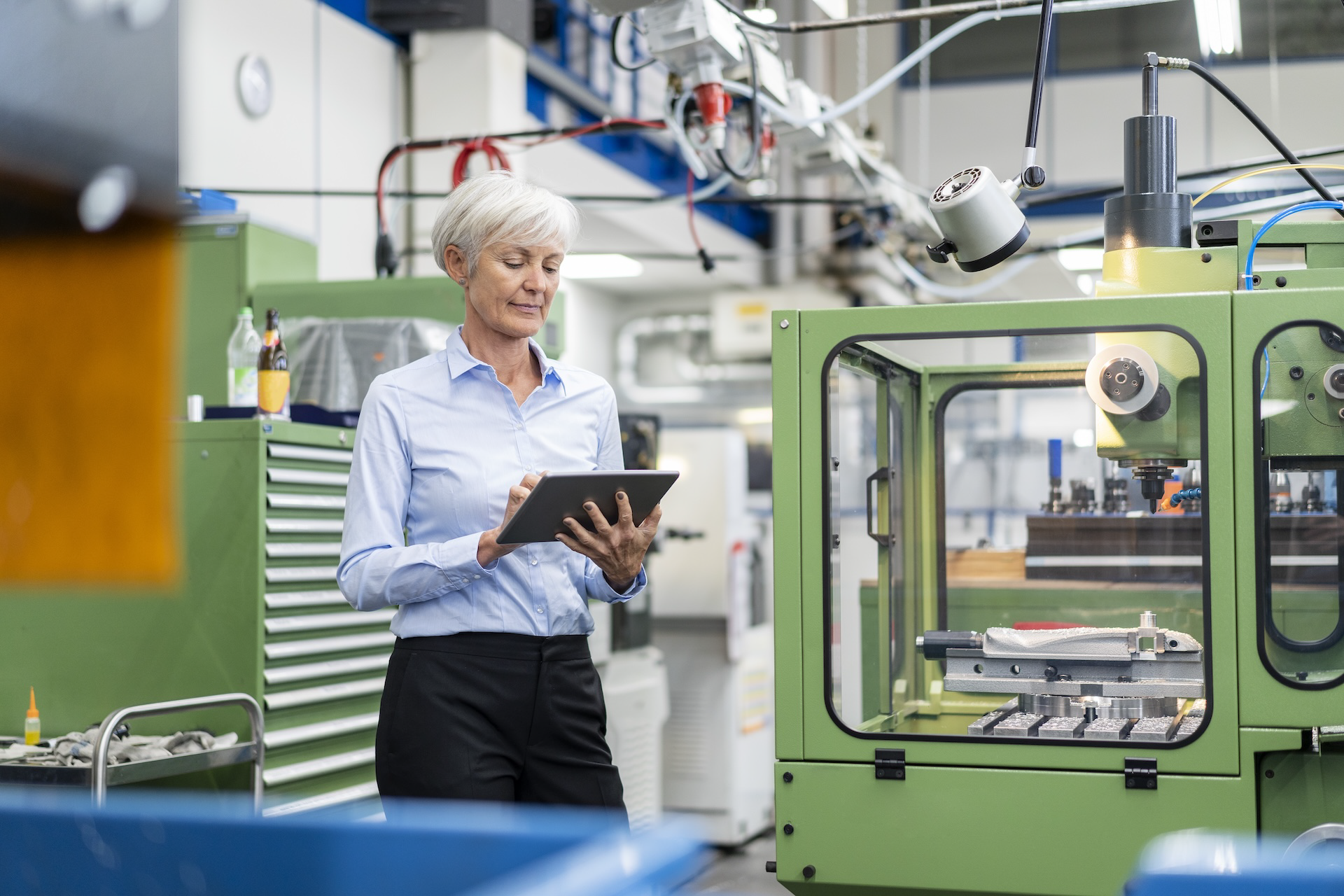 Gerente de pyme industrial analizando el margen bruto y el coach empresarial precio en una tablet.
