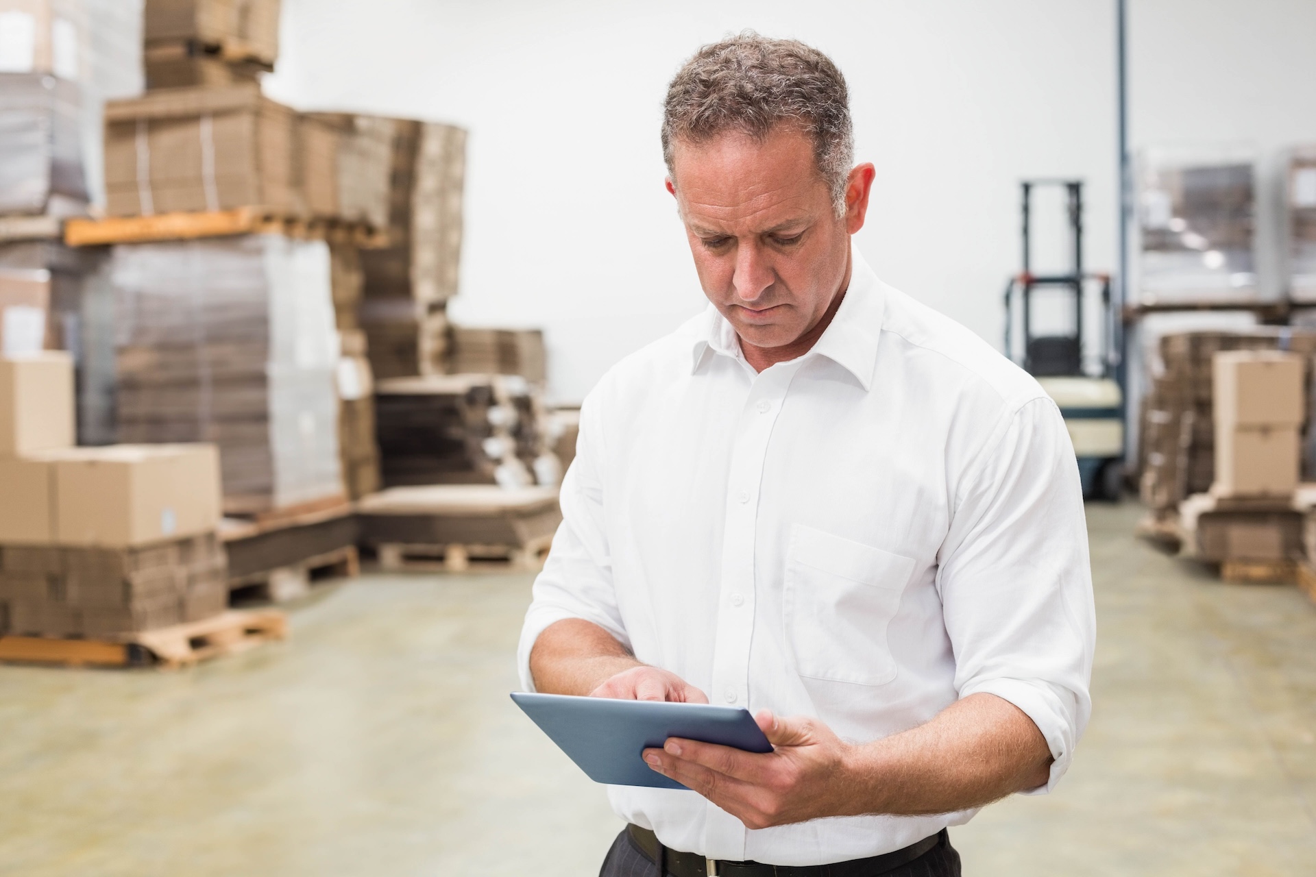 Responsable de una pyme consultando en una tablet los indicadores de una herramienta a medida creada durante las fases del coaching de negocios.