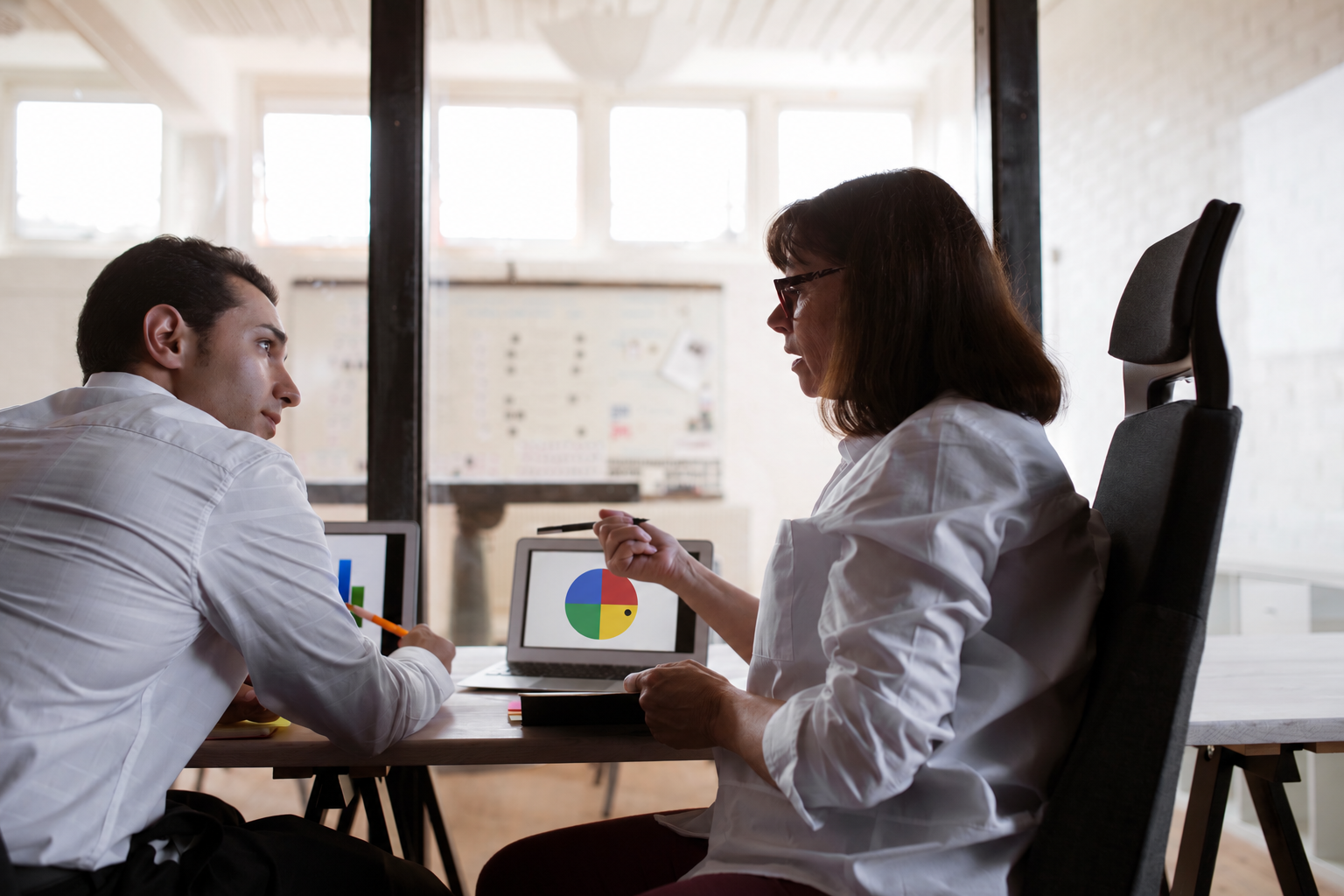 Dos profesionales analizando un perfil DISC en un ordenador, una de las herramientas de productividad más útiles para alinear equipos en tu empresa.