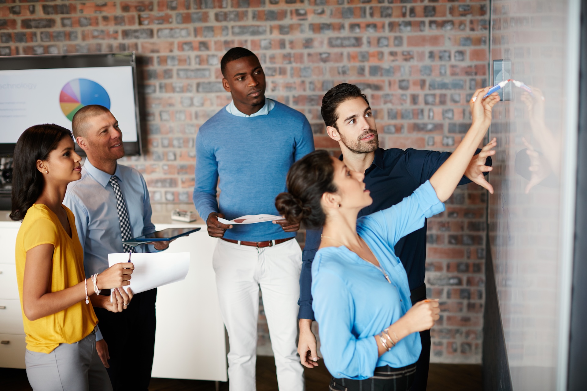 proceso-coaching-empresarial-planificacion-trimestral Equipo de una pyme planificando los objetivos del trimestre frente a un tablero de 12 semanas durante un proceso de coaching empresarial.
